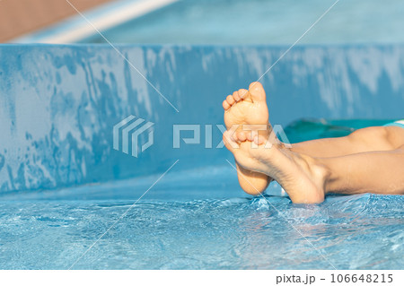 Close up of kid's feet, barefoot,in blue pool...の写真素材