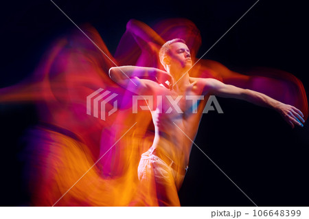 Chaotic movements. Young muscular shirtless man in motion against black studio background in neon with mixed lights effect Chaotic movements. Young muscular shirtless man in motion against black studio background in neon with mixed lights effect 106648399