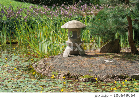 stone lantern on a small island in the middle of a pond in a Japanese garden 106649064