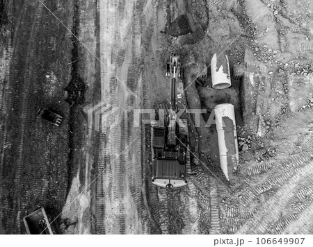 Excavator next to an open trench with two culverts ready for a connection juncture. Excavator next to an open trench with two culverts ready for a connection juncture. 106649907