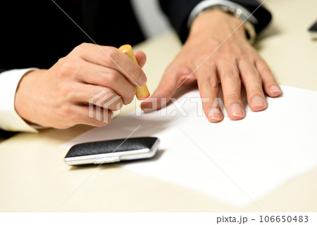 印鑑を押すビジネスマンの手元 106650483