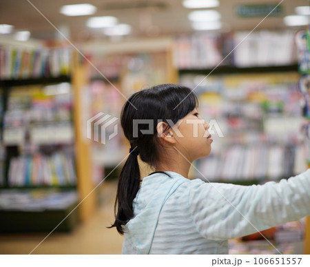本屋さんで本を探している小学生の女の子の様子 本屋さんで本を探している小学生の女の子の様子 106651557