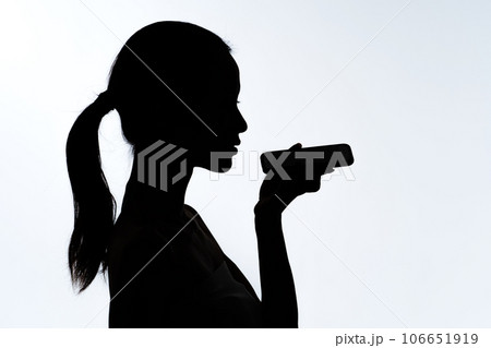 スマホで音声入力をする女性のシルエット 106651919