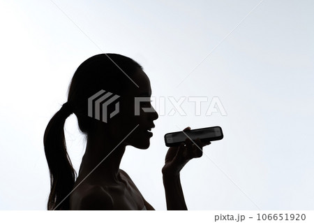スマホで音声入力をする女性のシルエット 106651920