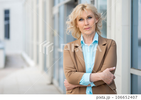 Strict director crosses arms standing against building Strict director crosses arms standing against building 106652407