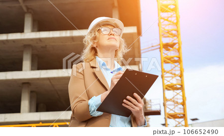 Entrepreneur makes notes on clipboard of building processes Entrepreneur makes notes on clipboard of building processes 106652490