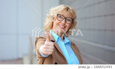 Positive female worker shows thumb up approving work Positive female worker shows thumb up approving work 106652493