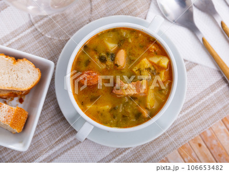 Served Galician pot, thick hot soup made from different types of meat and vegetables. 106653482