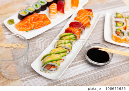 For several guests, Japanese lunch is served - set of uramaki rolls, soy sauce, 106653686