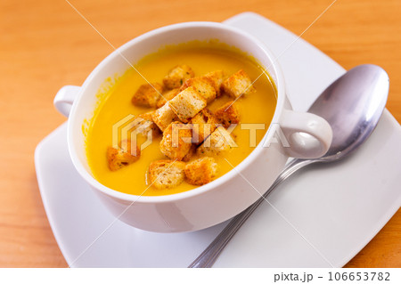 Light healthy carrot cream soup with croutons served in plate 106653782