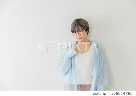 白壁に寄りかかる若い女性 106654766