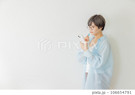 歯磨きしながら携帯を見る女性 106654791