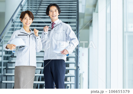 ヘルメットを持った作業服姿の男女 ヘルメットを持った作業服姿の男女 106655379