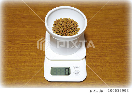 0gを示すデジタル上皿秤にキャットフードの入った器が載っている状態（イラスト風） 106655998