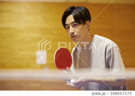 体育館の卓球台でサーブを構える男子大学生 体育館の卓球台でサーブを構える男子大学生 106657173