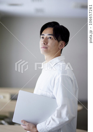 大学の教室でパソコンを抱き抱える日本人大学生の男性 106657261