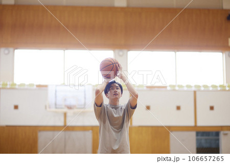 体育館でバスケットボールの練習をする日本人大学生の男性 106657265