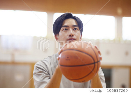 体育館でバスケットボールの練習をする日本人大学生の男性 106657269