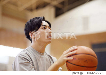 体育館でバスケットボールの練習をする日本人大学生の男性 106657270