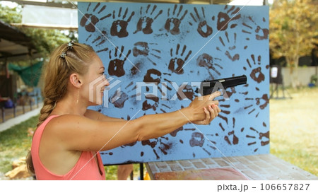 Woman shoots at shooting range with pneumatic gun. Outdoors entertainment for tourists in Thailand.Active leisure on vacation, traveling in Asia.Practice in shooting gallery safe legal pistol weapons. Woman shoots at shooting range with pneumatic gun. Outdoors entertainment for tourists in Thailand.Active leisure on vacation, traveling in Asia.Practice in shooting gallery safe legal pistol weapons. 106657827