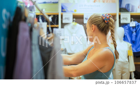 Beautiful woman shopper customer is looking and buying colorful casual clothes in clothing store.Happy smile confident client buying or watching casual modern outerwear or underwear in clothing store. Beautiful woman shopper customer is looking and buying colorful casual clothes in clothing store.Happy smile confident client buying or watching casual modern outerwear or underwear in clothing store. 106657837