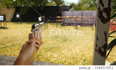 Tourist shoots at shooting range with pneumatic gun. Outdoors entertainment for tourists in Thailand. Active leisure on vacation, traveling in Asia. Close up shooting gallery safe legal pistol weapon. Tourist shoots at shooting range with pneumatic gun. Outdoors entertainment for tourists in Thailand. Active leisure on vacation, traveling in Asia. Close up shooting gallery safe legal pistol weapon. 106657851