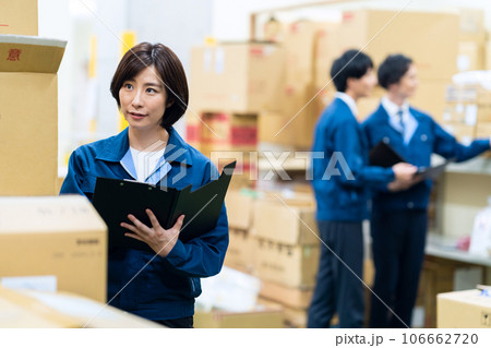 配送センターで働く作業服を着た男女の社員 106662720