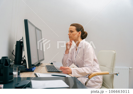 Focused professional doctor radiologist analyzing scan MRI images on computer in medical center 106663011