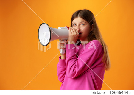 Teen girl making announcement with megaphone on yellow background Teen girl making announcement with megaphone on yellow background 106664649