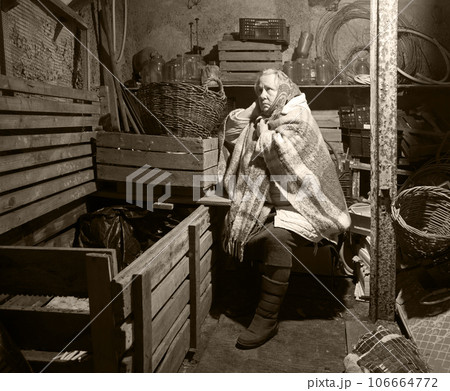 A woman hides in a cellar from shelling 106664772