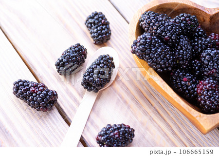 Freshly picked organic blackberries in a heart shaped bowl on a light wooden table. Blackberry. Healthy eating, vegan food or diet concept Freshly picked organic blackberries in a heart shaped bowl on a light wooden table. Blackberry. Healthy eating, vegan food or diet concept 106665159