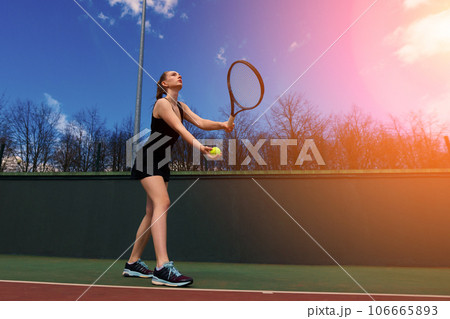 Sexy girl tennis player holding tennis racket on the court. Young woman is playing tennis. Sexy girl tennis player holding tennis racket on the court. Young woman is playing tennis. 106665893