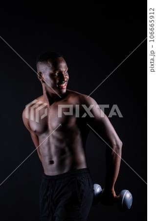 Athletic man doing exercise for arms with dumbbells. Muscular fitness model strength and motivation. Athletic man doing exercise for arms with dumbbells. Muscular fitness model strength and motivation. 106665912
