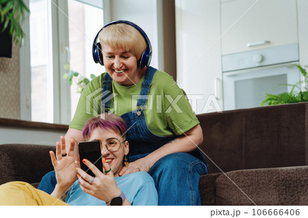 Daughter teaches her mother basics of online commerce and shopping on smartphone Daughter teaches her mother basics of online commerce and shopping on smartphone 106666406