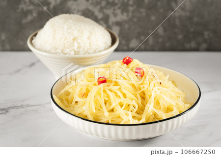 Stir-fried potato shreds and rice on a stone slab table. Stir-fried potato shreds and rice on a stone slab table. 106667250