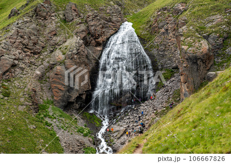 Mountain landscape with waterfall. natural background, trekking, mountain walks, healthy and active lifestyle. Girl's braids waterfall 106667826