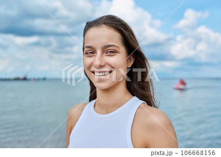 Portrait of smiling teenage girl outdoor on sea background Portrait of smiling teenage girl outdoor on sea background 106668156