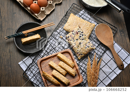 Top view of slices of tempe on the wooden kitchen tabletop. Food from fermented beans or cereals 106668252