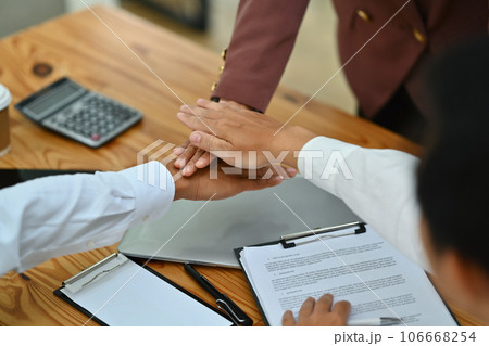 Group of businesspeople stacking hands together, motivating, team building or celebrate their unity in the office Group of businesspeople stacking hands together, motivating, team building or celebrate their unity in the office 106668254