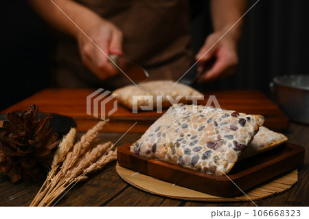 Closeup view of law tempe made from black beans on kitchen tabletop. Vegan appetizers, traditional Indonesian soy product Closeup view of law tempe made from black beans on kitchen tabletop. Vegan appetizers, traditional Indonesian soy product 106668323