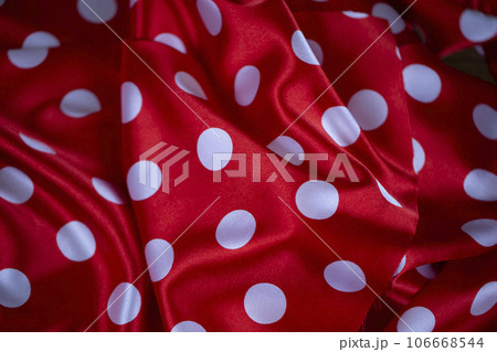 Red silk fabric with large white polka dots. Polka dot background. Red silk fabric with large white polka dots. Polka dot background. 106668544