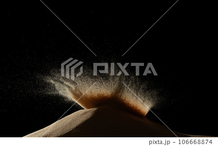 Deep impact on sand hill and splash all over area. Sand dune hill over wind storm and blast dust splash over mountain. Sunshine rain fall on sand hill wind blow. Black background isolated 106668874