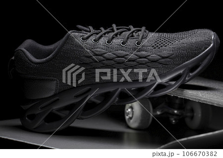 A black sneaker stands on a skateboard. Sport shoes. 106670382