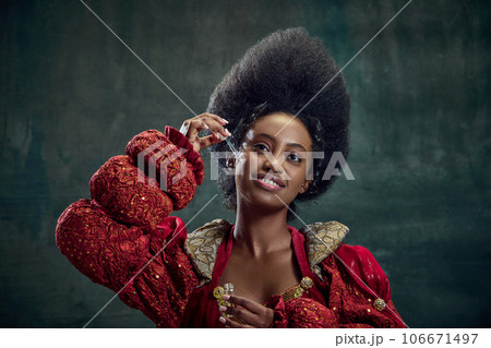 Skincare and cosmetology. Beautiful african woman, princess using face serum against vintage green background Skincare and cosmetology. Beautiful african woman, princess using face serum against vintage green background 106671497