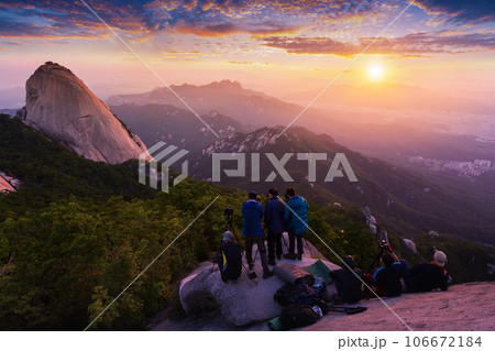 Photographer is taking a photo of the sunrise in the morning on Bukhansan mountains , Seoul, South Korea. Photographer is taking a photo of the sunrise in the morning on Bukhansan mountains , Seoul, South Korea. 106672184