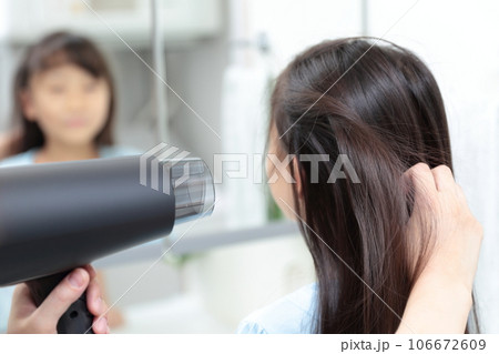娘の髪の毛をドライヤーで乾かすママの手 106672609
