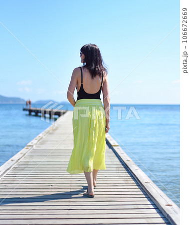 45 years old Russian woman walking on pier against Japanese sea 106672669