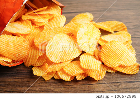 Potato chips in open bag, delicious BBQ seasoning spicy for crips, thin slice deep fried snack fast food. 106672999