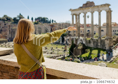 A happy blond 30s woman tourist is standing near the Roman Forum, old ruins at the center of Rome, Italy. Concept of traveling famous landmarks A happy blond 30s woman tourist is standing near the Roman Forum, old ruins at the center of Rome, Italy. Concept of traveling famous landmarks 106674632