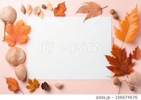 Autumn leaves on peach table, white sheet of paper 106674676
